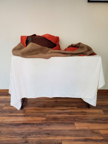 Fabric in Fall seasonal colors like burnt orange and textures like burlap used to create a pretty base for an in-home buffet. 