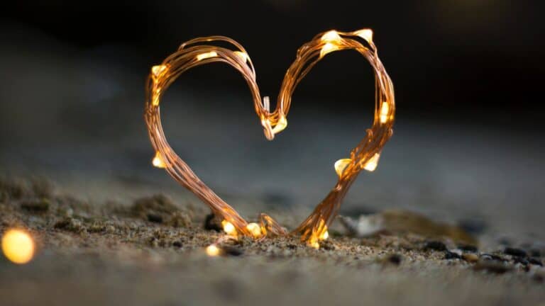 heart made out of string lights in the sand